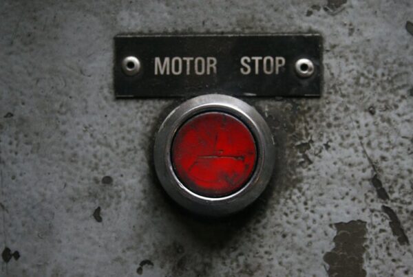 Red emergency stop button on a metal industrial panel