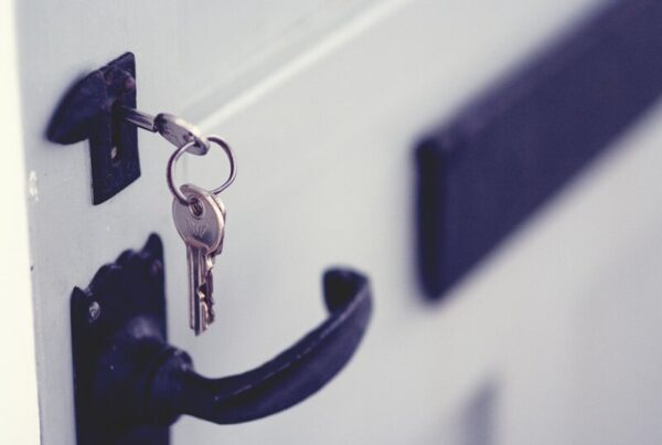 A black and silver padlock fixed to a white door
