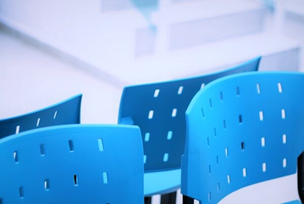 A row of empty blue waiting room chairs, representing a game stuck waiting for randomness to arrive