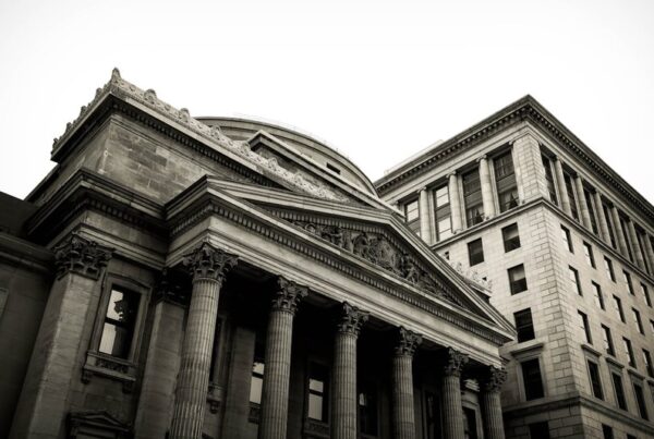 Grey concrete bank building, representing institutional finance moving onto permissioned blockchain ledgers