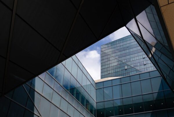 Glass office towers seen from below, separated by a gap of sky