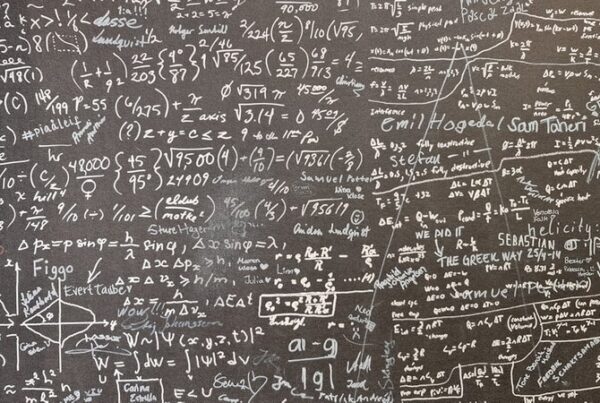 A blackboard densely covered in handwritten mathematical working