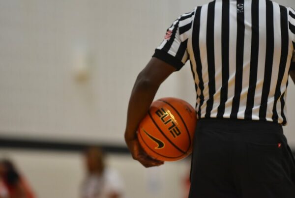 A referee holding a basketball on a court