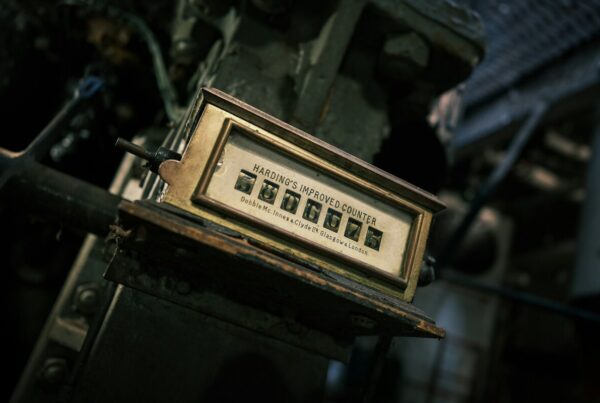 Vintage brass mechanical counter with rotating digits mounted on industrial machinery