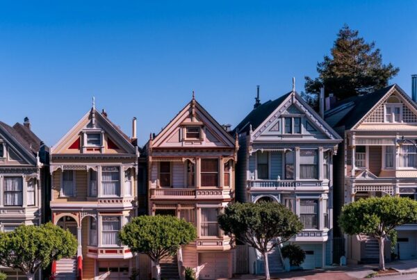A row of five Victorian houses painted in different colours, all built to the same structural plan