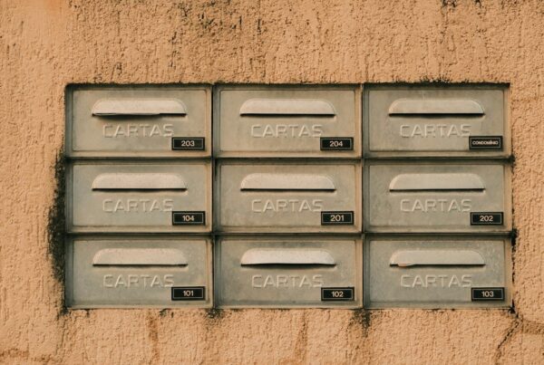 A grid of nine identical numbered metal mailboxes on a wall, each labelled CARTAS, with no way to tell which are occupied