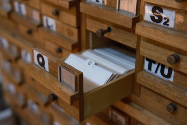 A wall of numbered and lettered wooden card-catalogue drawers, one pulled open to reveal index cards