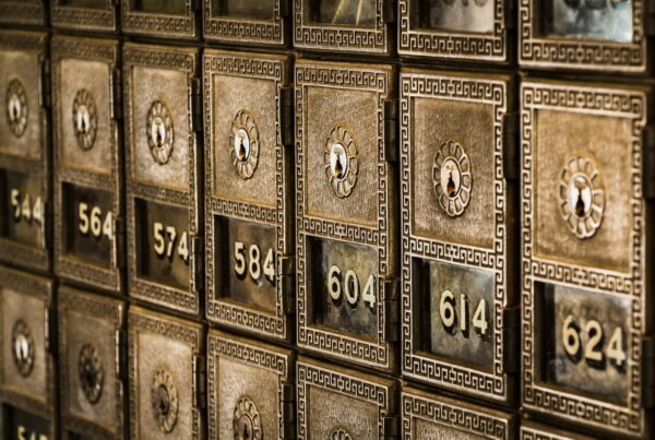 Rows of numbered brass deposit boxes in a bank, each with a keyhole