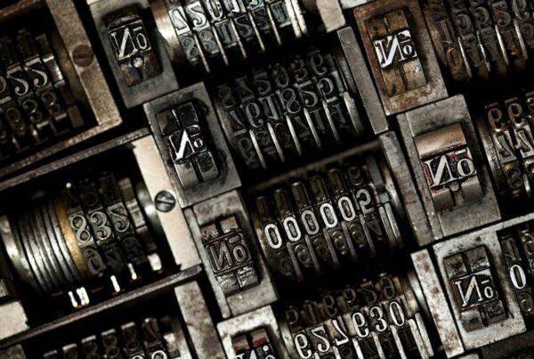 A dense tray of vintage printing press numbering units, metal digit wheels mid-count, one reading 00000