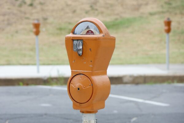 An orange parking meter reading TIME EXPIRED beside an empty car park