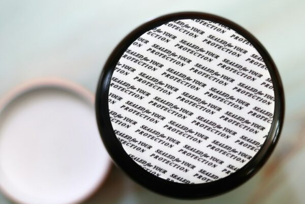 A jar lid sealed with foil printed repeatedly with the words SEALED FOR YOUR PROTECTION