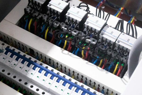 A consumer unit with two rows of individual miniature circuit breakers, each one switching a single circuit, wired in blue, red and yellow.